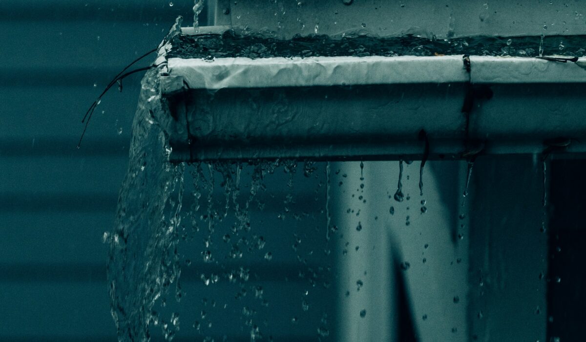 A cracked gutter that is unable to send water away from the house, potentially leading to foundational damage.