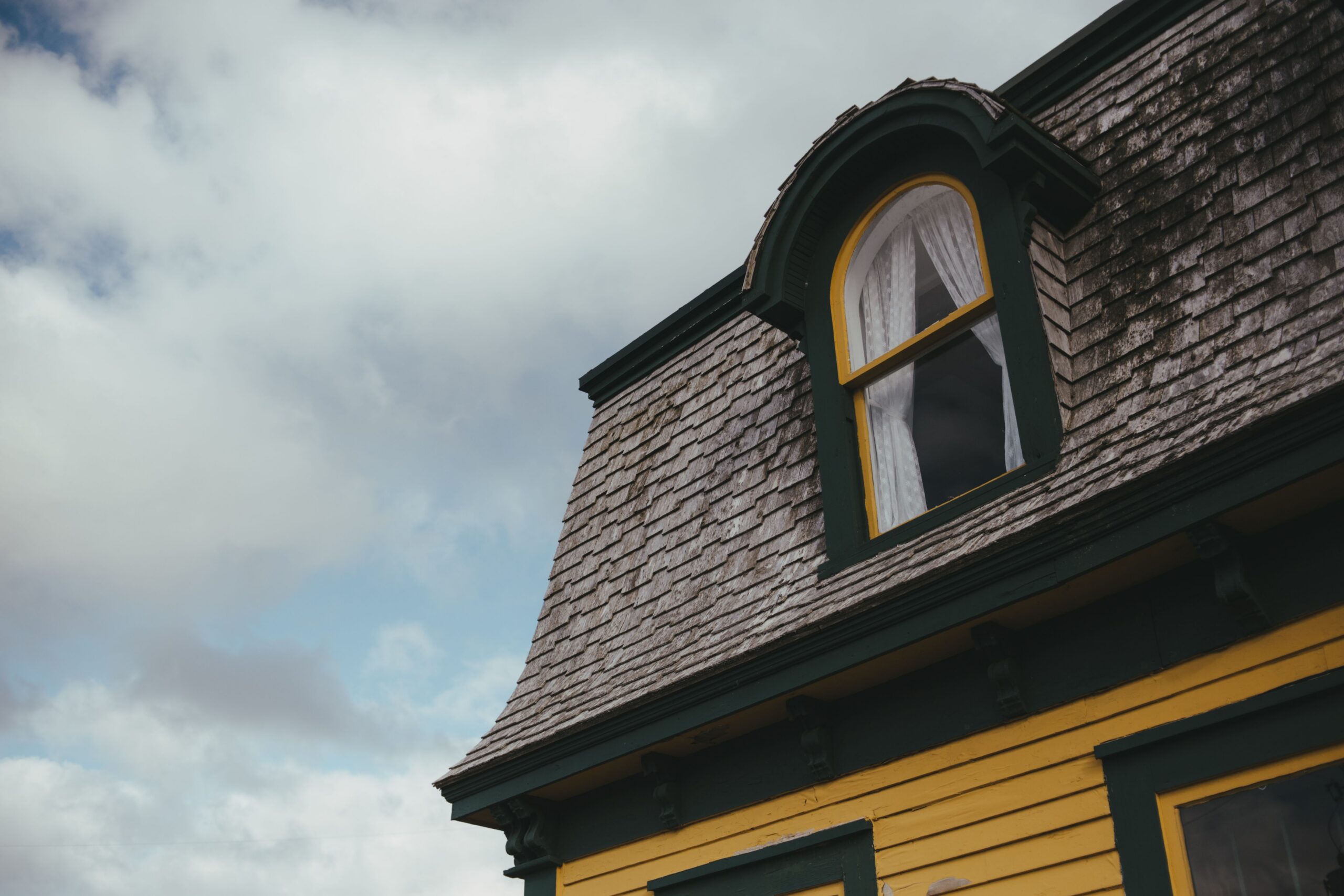 An older home with roof discoloration. A roof inspection can help diagnose the issue.