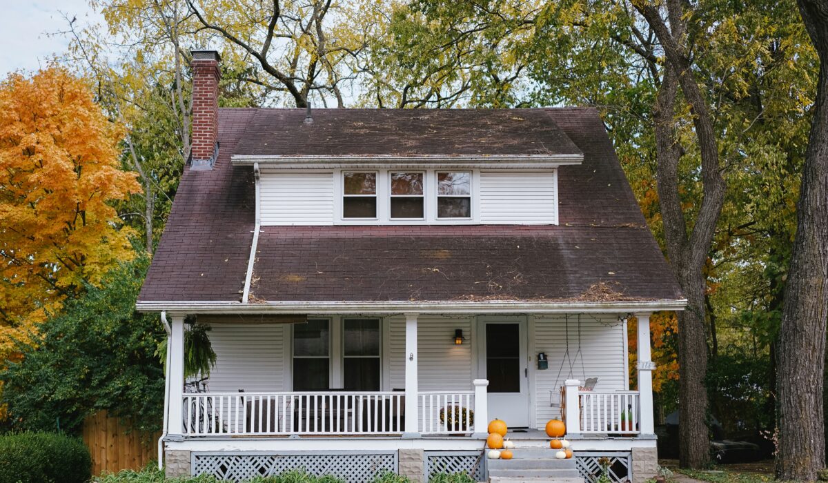 A house in the fall with visible roof damage.