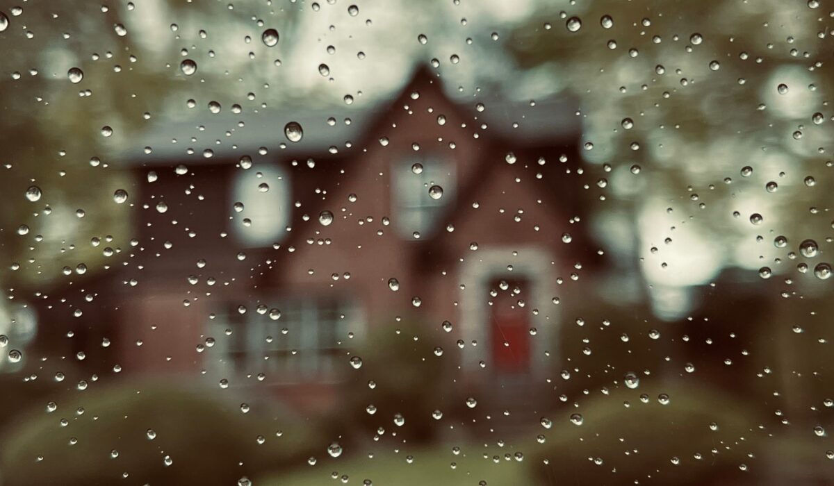 A house outside of a fogged window, which can be sign of excess moisture in a home...and the beginning of a musty scent.